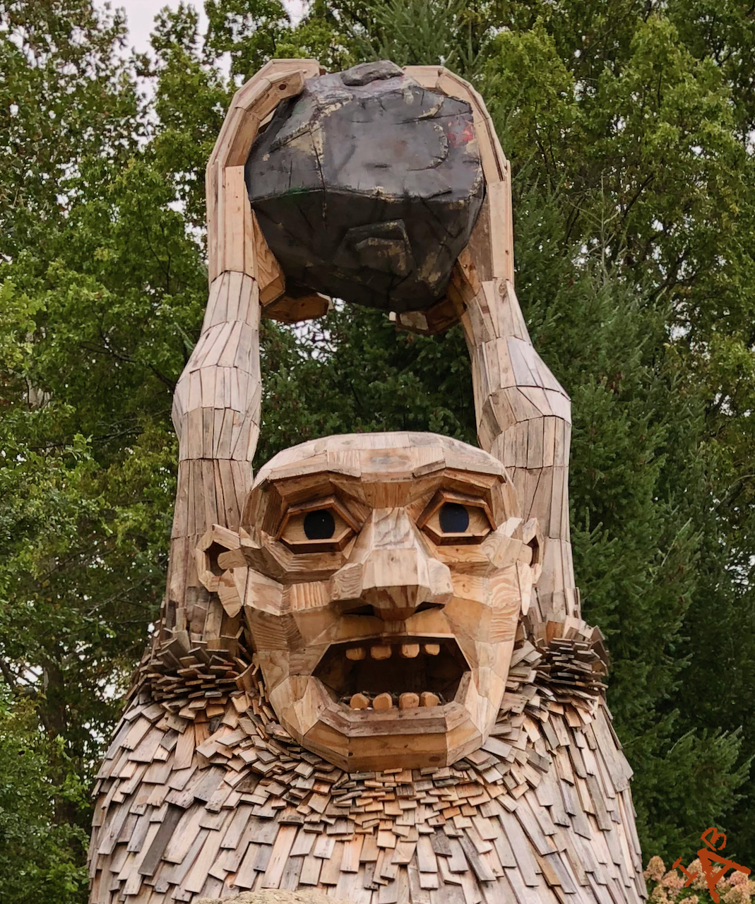A troll at the Morton Arboretum holding a rock.